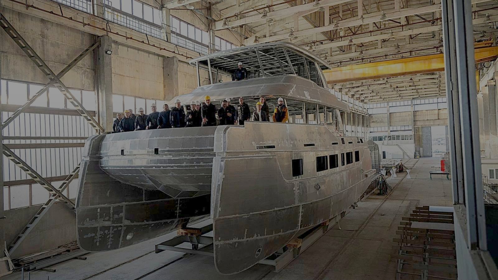 Aluminium catamaran hull in the Burgas hall, with the yard team on deck